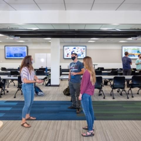 Students standing in hall by classroom