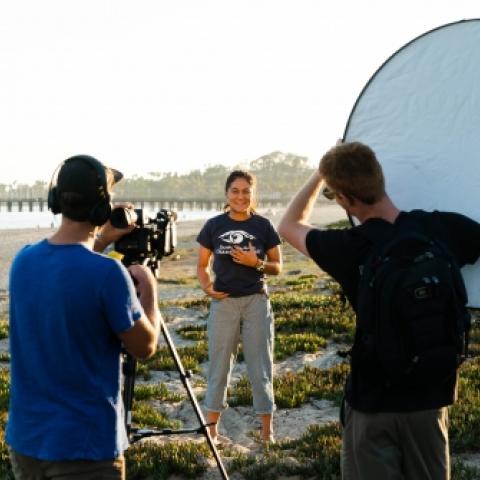 Students in a video shoot on the beach